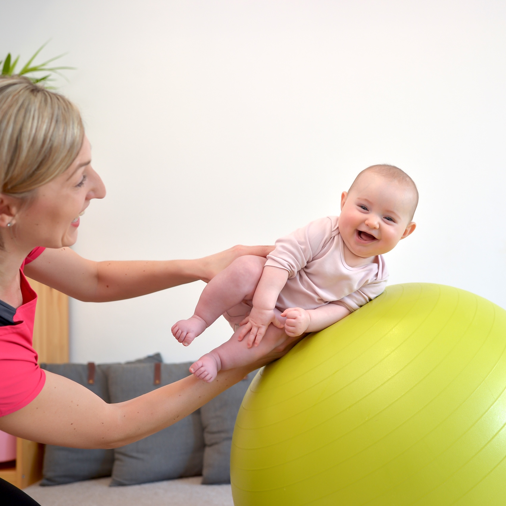 Maminka cvičí s miminkem na Gymballu pro rozvoj rovnováhy a stability.